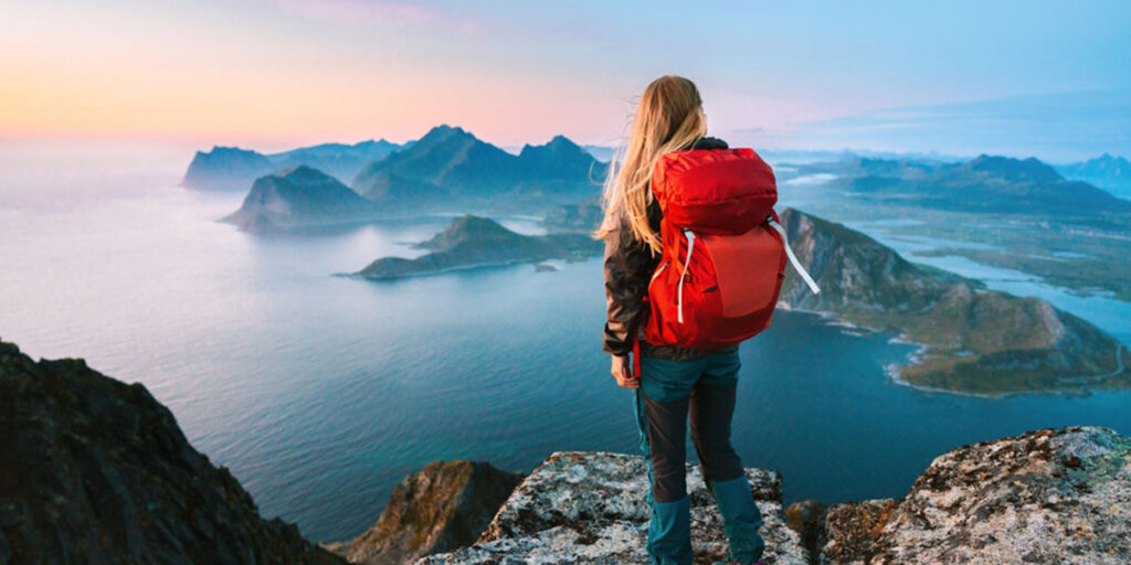 a woman with bagpack watching the ocean