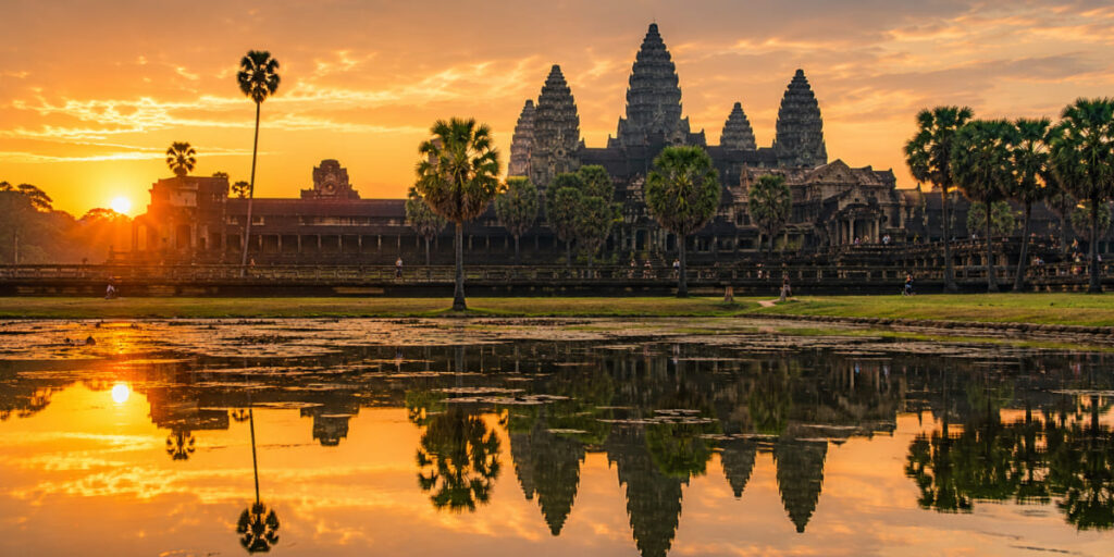 Sunrise over the towers of Angkor Wat reflected in the moat, Cambodia
